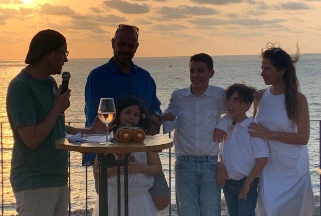 טקס משפחתי בשקיעה על שפת המים